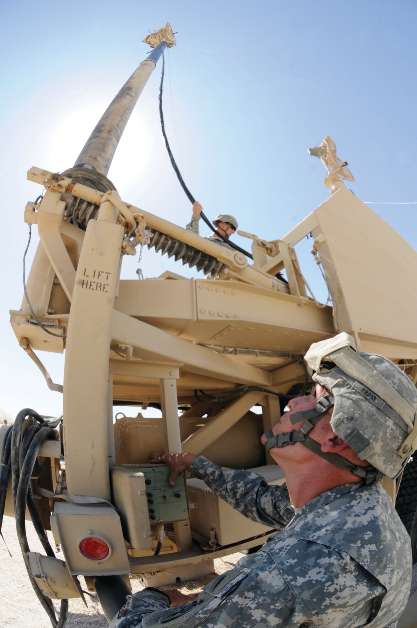 Specialist Cary presses a button to lower the antenna on an antenna mast group while Army Sgt. Frank Puleo, communications signal support systems specialist assigned to Alpha 2-43, secures the cable. These Alpha 2-43 members are responsible for effectively providing communications so they can have clear situational awareness.  Specialist Cary, a native of Myrtle Beach, S.C., and Sergeant Puleo, a native of Houston, Texas, are deployed from Fort Bliss, Texas. (U.S. Air Force photo by Staff Sgt. Darnell T. Cannady)