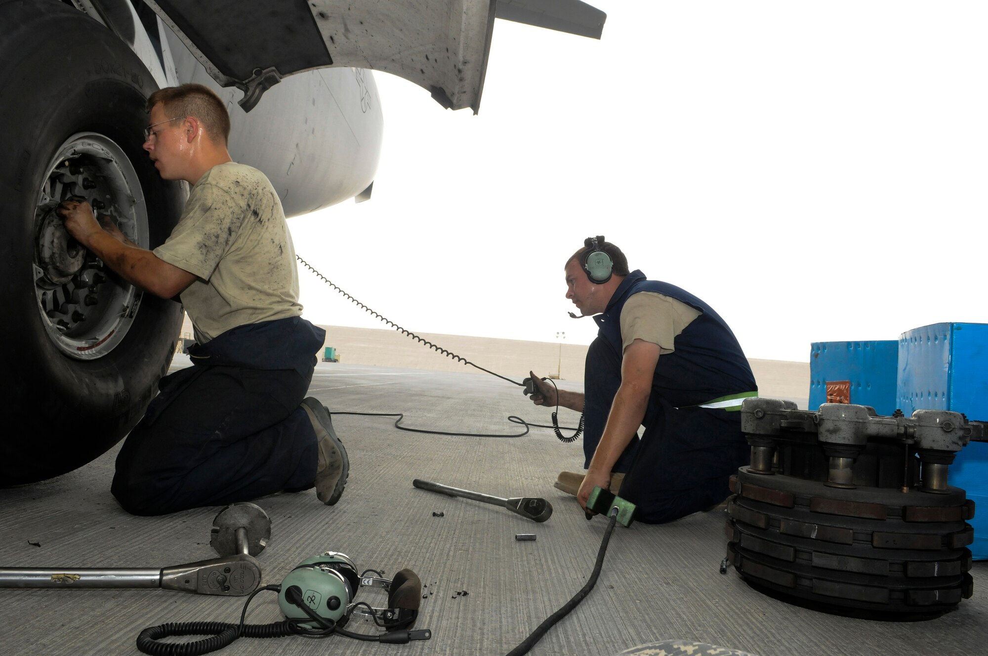 Staff Sgt. Branson Standridge, 8th Expeditionary Air Mobility Squadron, lowers the self-contained jack on a C-17 Globemaster III, while Airman 1st Class Cody Hickman tightens a wheel after a brake change, October 23.  The C-17 is capable of rapid strategic delivery of troops and all types of cargo to main operating bases or directly to forward bases in the Central Command area of responsibility.  Sergeant Standridge is a native of Atkins, Ark., and Airman Hickman hails from Danbury, Texas.  Both are deployed from Charleston Air Force Base, S.C., in support of Operations Iraqi and Enduring Freedom and Joint Task Force-Horn of Africa.  (U.S. Air Force photo by Tech. Sgt. Michael Boquette/Released)