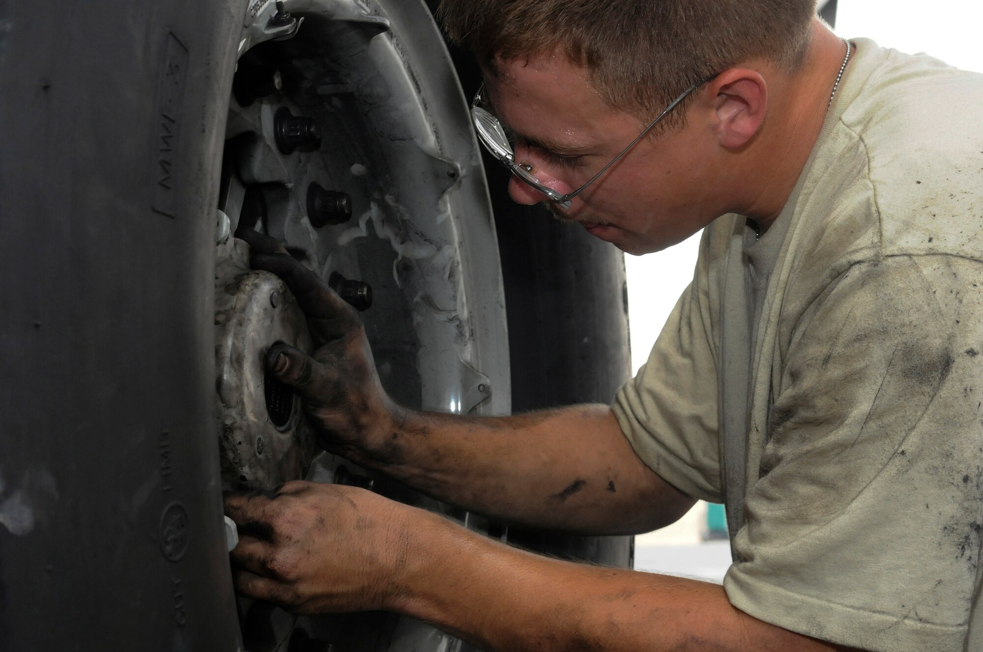 Airman 1st Class Cody Hickman, 8th Expeditionary Air Mobility Squadron, carefully tightens each nut in place securing the wheel of a C-17 Globemaster III, October 23.  The tire is the last step in the process of completing a brake change at an undisclosed air base in Southwest Asia. The C-17 is capable of rapid strategic delivery of troops and all types of cargo to main operating bases or directly to forward bases in the Central Command area of responsibility.  Airman Hickman hails from Danbury, Texas, and is deployed from Charleston Air Force Base, S.C., in support of Operations Iraqi and Enduring Freedom and Joint Task Force-Horn of Africa.  (U.S. Air Force photo by Tech. Sgt. Michael Boquette/Released)