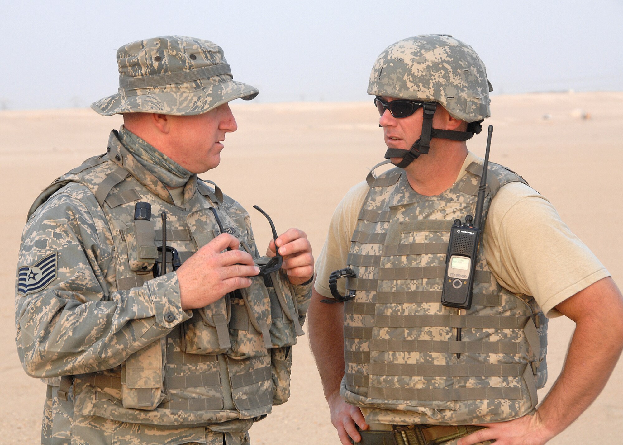 SOUTHWEST ASIA -- Tech. Sgt. Brent Stiefel, 386th Expeditionary Security Forces Squadron Viper team leader, left, talks to Tech. Sgt. Peter McNally, 386th Expeditionary Civil Engineer Squadron Explosive Ordinance Disposal team, about the procedures for disposing of unexploded ordnance on Oct. 22 at an air base in Southwest Asia. The Viper teams patrol the area outside of the base for UXO's and interact with the local population to ensure a relationship with the host nation remains strong. Sergeant Stiefel is deployed from Kadena Air Base, Japan. Sergeant McNally is deployed from Tyndall Air Force Base, Fla. (U.S. Air Force photo/Tech. Sgt. Raheem Moore)