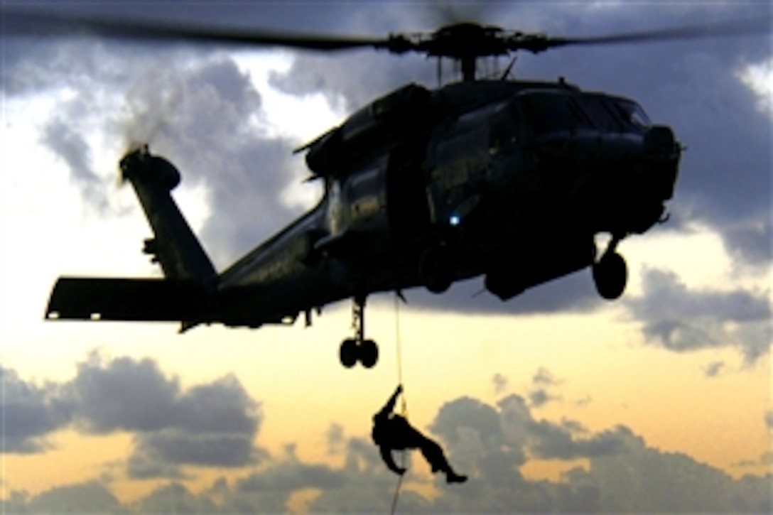 A U.S. Navy sailor rappels from an HH-60H Sea Hawk helicopter to the flight deck of the Nimitz-class aircraft carrier USS George Washington during training in the Pacific Ocean, Oct. 23, 2008.  The sailor is assigned to the Explosive Ordnance Disposal Detachment 5, and the helicopter and its crew are part of Helicopter Anti-Submarine Squadron 14.