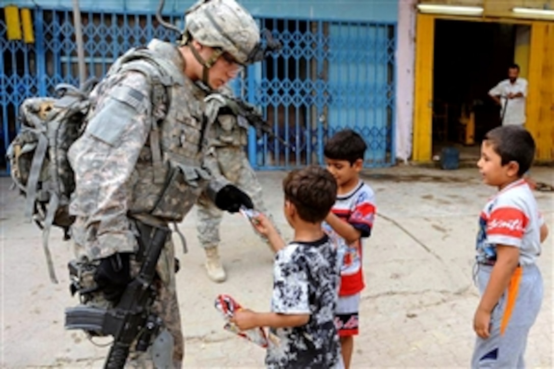 U.S. Army Sgt. Thomas Dwyer passes out soccer playing cards to Iraqi children while conducting a patrol in a market in Baghdad, Iraq, Oct. 22, 2008. Dwyer is assigned to the 4th Infantry Division's 3rd Brigade Combat Team Command Security Detachment.