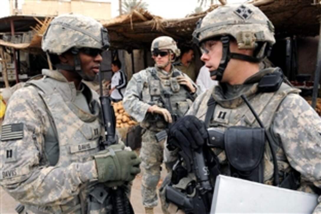 U.S. Army Capt. Errol Davis, left, and Capt. Adam Hoffmann discuss the progress of a on-going patrol they are conducting in the city of Baghdad, Iraq, Oct. 15, 2008. Davis is assigned to  Battery A 3rd Battalion, 29th Field Artillery Regiment and Hoffmann is assigned to the 4th Infantry Division's 3rd Brigade Combat Team. They are conducting the patrol to show a strong presence in the local community.