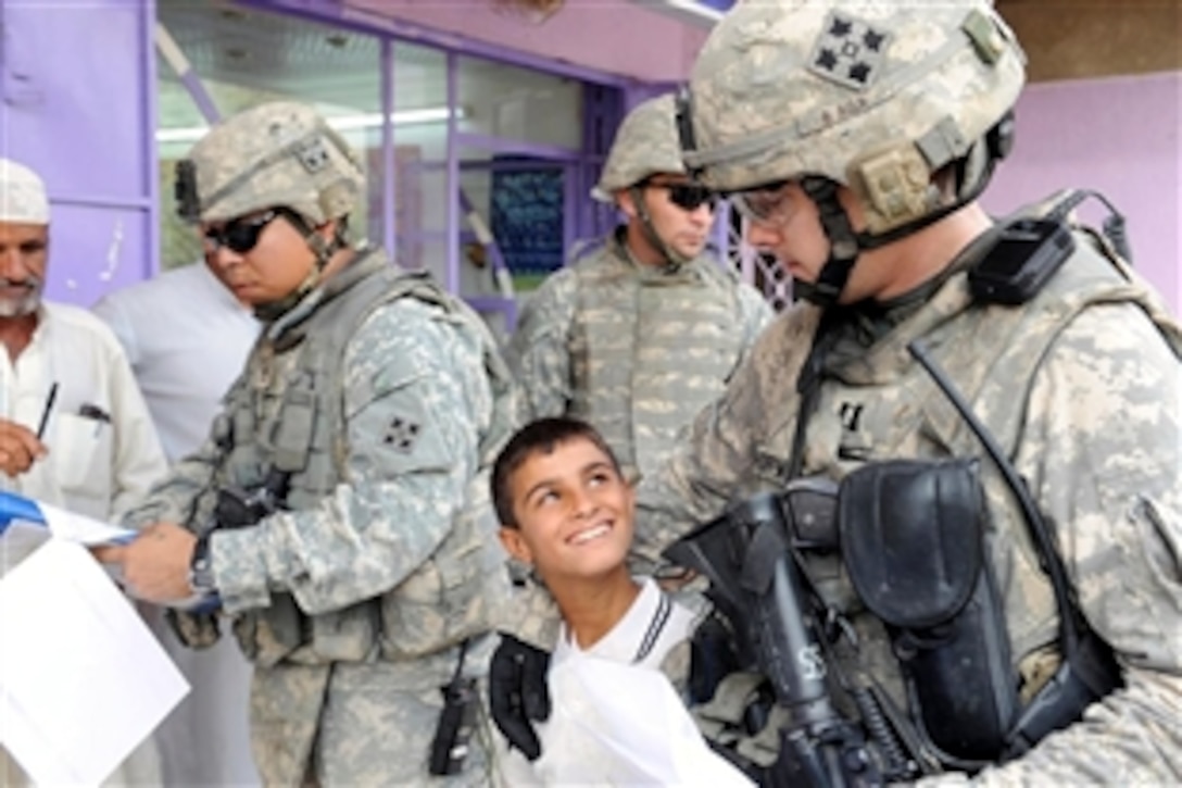 An Iraqi boy greets U.S. Army soldiers as they travel through the streets of Baghdad, Iraq, stopping at various shops, Oct. 15, 2008. The soldiers, assigned to the 4th Infantry Division's Command Security Detachment, 3rd Battalion Combat Team, working to provide local shop owners with micro-grants to improve their businesses. 
