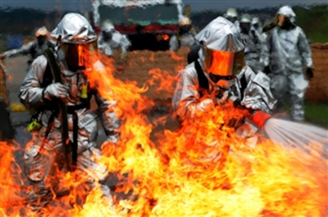 Daniel Scherer (right) and Tech. Sgt. Christopher Parker, both fire fighters from the 835th Civil Engineer Squadron, battle a ground fire during mobile aircraft firefighting training at Ramstein Air Base, Germany, on Oct. 21, 2008.  