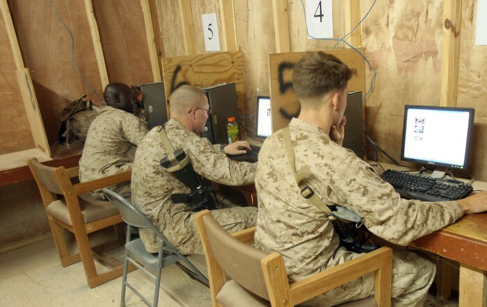 Marines with 3rd Battalion, 7th Marine Regiment, Regimental Combat Team 5 use the computers at the Marine Welfare and Recreation Center at Camp Hit, Iraq, Oct. 14, to keep in touch with friends and family. The MWR Center features numerous phones and computers that Marines can use to stay connected to their loved ones during their deployment to Iraq.::r::::n::