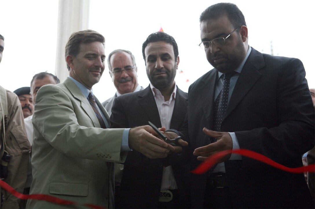 Hussein Ali Hussein (right), the Habbaniyah District Mayor, Ali Dawood (center), the Chairman of the Habbaniyah City Council and Kevin Anderson (left), a representative from the Embedded Provincial Reconstruction Team – Ramadi, cut the ceremonious ribbon at the Habbaniyah Government Center’s grand opening, Oct. 25. The government center has been four months in the making and is now complete, standing as a symbol of a representative government taking hold in the area.