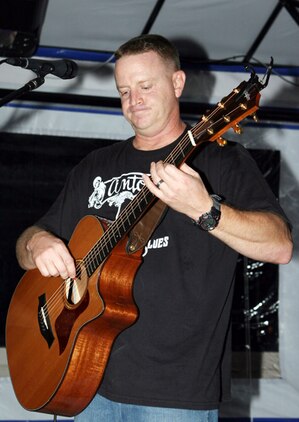 Lt. Col. Mike Corrado strums his guitar Oct. 26 during his performance at a local entertainment center. Corrado  has recently released his seventh CD, Start Saving Me.