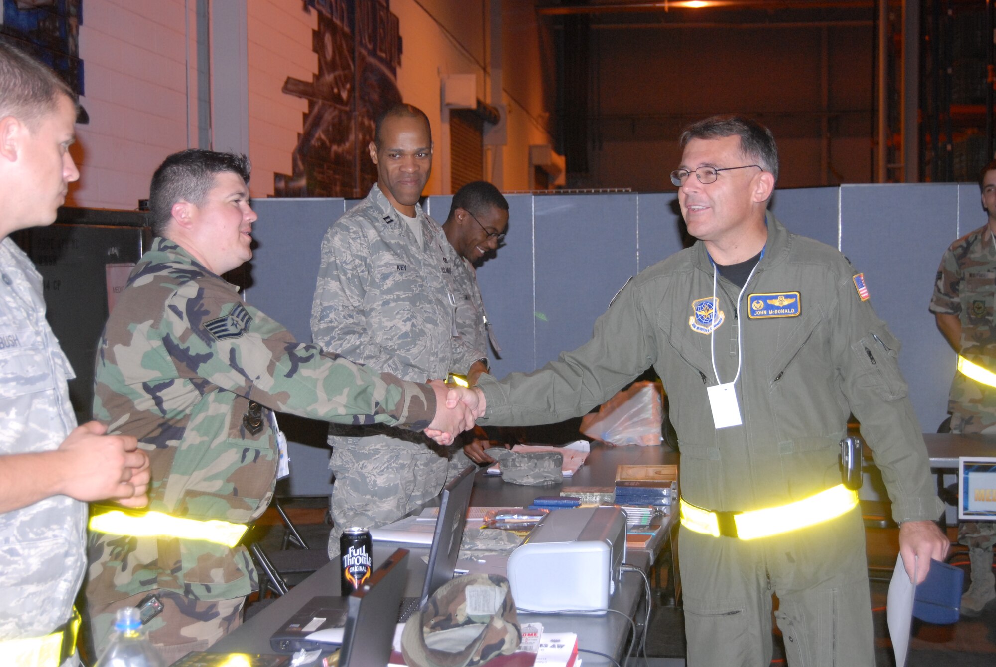Col. John McDonald, 43rd Airlift Wing Commander, shakes hands with all the members at the PDF line table during the Operational Readiness Exercise at the 43rd Logistics Readiness Squadron’s building Oct. 16. Colonel McDonald acted as the facilitator for the inventory checks of the mobility bags for the various chalks throughout the morning. (Photo by Airman 1st Class Mindy Bloem)