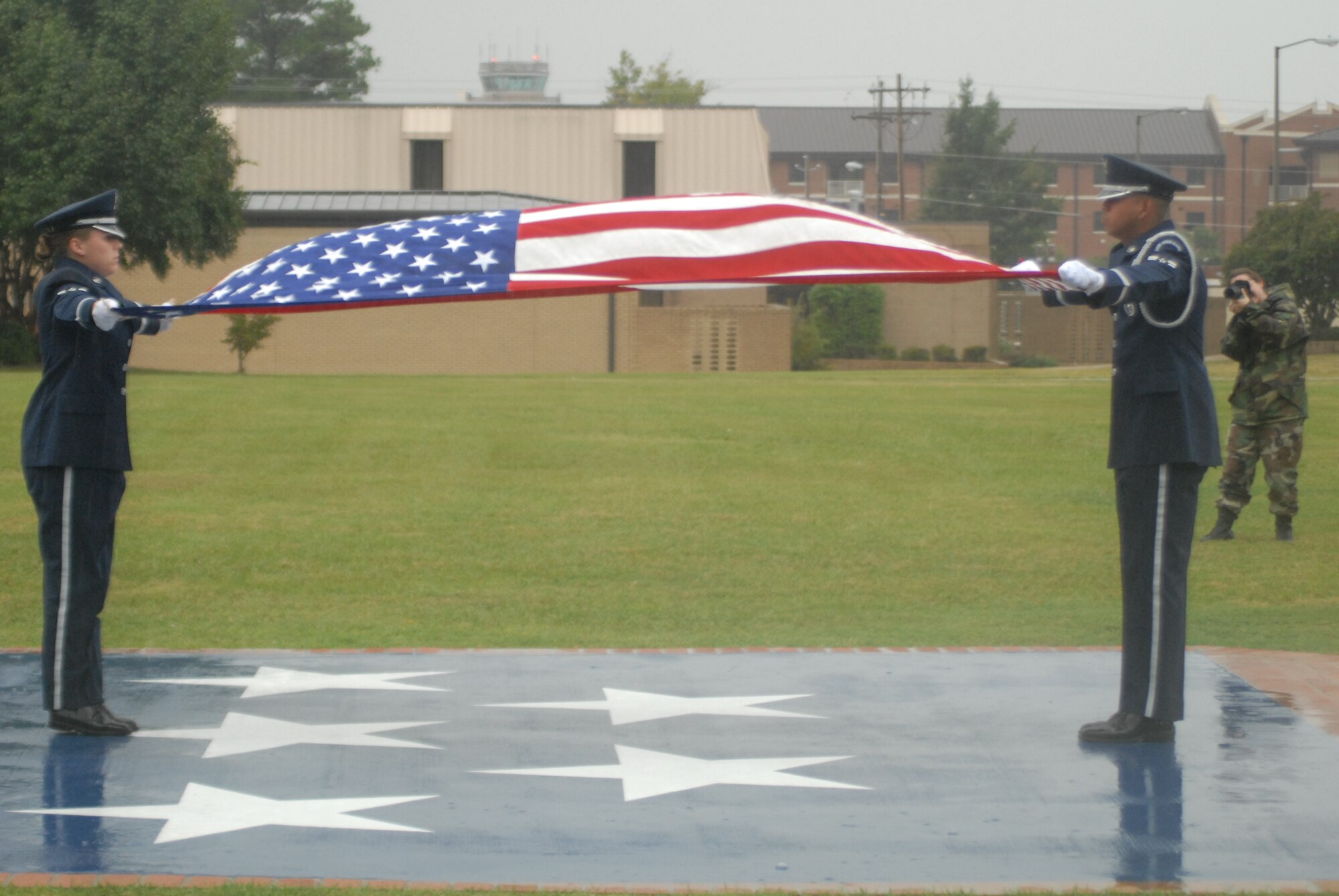 Airmen 1st Class Brittany Hurdle and David Cedeno, 43rd Airlift Wing Honor Guard team members, prepare to fold the flag following the playing of retreat as part of a ceremony Oct. 17. (U.S. Air Force Photo by Staff Sgt. Jon LaDue) 