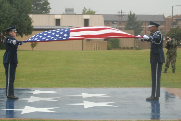 Airmen 1st Class Brittany Hurdle and David Cedeno, 43rd Airlift Wing Honor Guard team members, prepare to fold the flag following the playing of retreat as part of a ceremony Oct. 17. (U.S. Air Force Photo by Staff Sgt. Jon LaDue) 