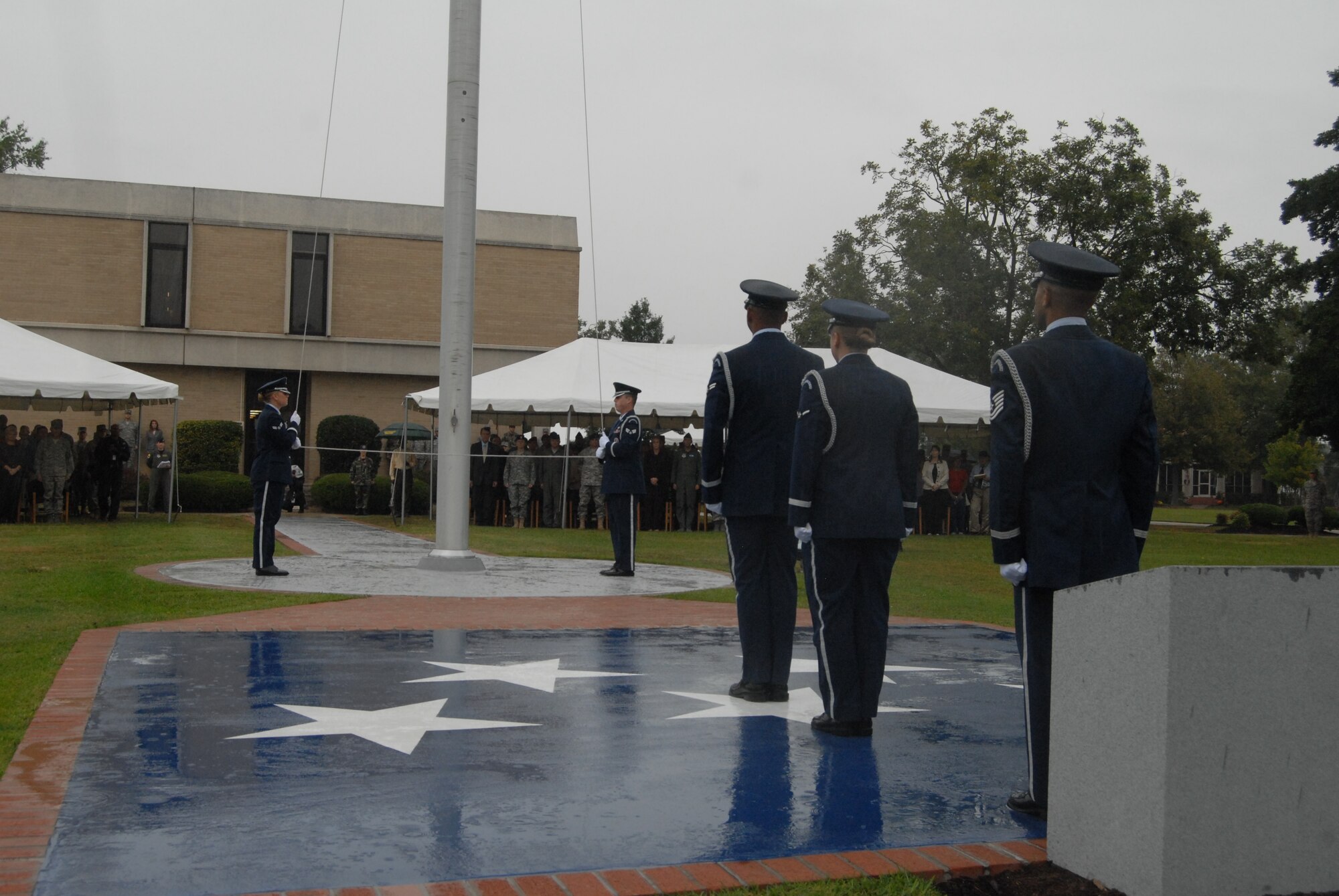 Members of the 43rd Airlift Wing Honor Guard lower the flag and stand on the newly dedicated Lt. Joseph R. Sarnoski Parade Field during retreat as part of the ceremony Oct. 17. (U.S. Air Force Photo by Staff Sgt. Jon LaDue) 