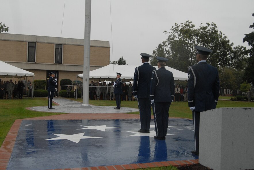 Members of the 43rd Airlift Wing Honor Guard lower the flag and stand on the newly dedicated Lt. Joseph R. Sarnoski Parade Field during retreat as part of the ceremony Oct. 17. (U.S. Air Force Photo by Staff Sgt. Jon LaDue) 