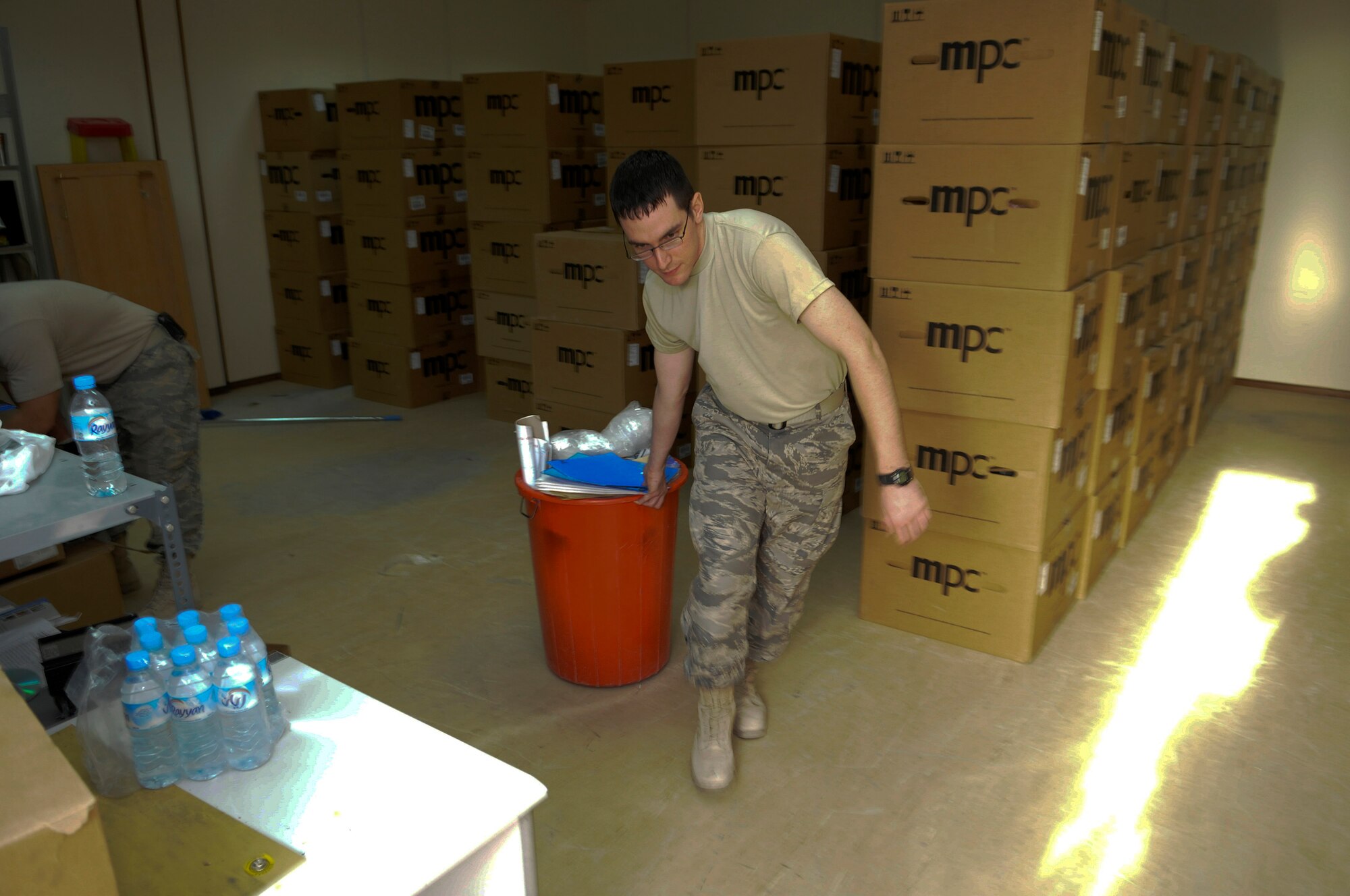 Airman 1st Class Jeffrey Hyatt, assigned to Ground Radio in the 379th Expeditionary Communications Squadron, drags out a bin of trash October 25, 2008, at an undisclosed air base in Southwest Asia.  The Ground Radio shop is cleaning house as part of a move to a new building.  Airman Hyatt hails from Woodbine, Ga. and is deployed from Shaw Air Force Base, S.C., in support of Operations Iraqi and Enduring Freedom and Joint Task Force-Horn of Africa.  (U.S. Air Force photo by Tech. Sgt. Michael Boquette/Released)