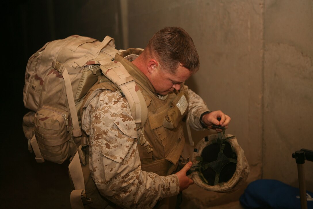 Master Sgt. William 'Spanky' Gibson, force fires chief, Multi National Force - West, throws on his kevlar while getting ready to depart Camp Fallujah.  Gibson, from Pryor, Okla., is headed back to the states to begin his tenure as one of the three first Marine Corps staff non-commissioned officers selected for a Congressional Fellowship.