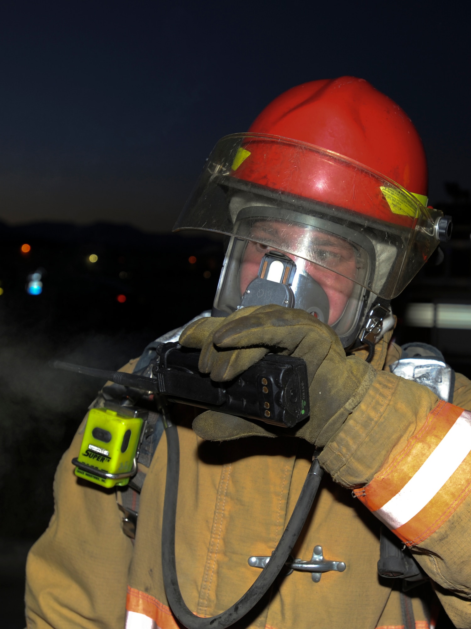 ELMENDORF AIR FORCE BASE Alaska -- Staff Sgt. Adam Burgess, a 3rd Civil Engineer Squadron fire fighter, calls into headquarters to give an onscene status report during the Emergency Management Exercise here Oct. 27. Onscene officials are constantly in contact with their headquarters to ensure that the whole unit is on the same page while the incident is occurring. (U.S. Air Force Photo/Staff Sgt. Joshua Garcia)