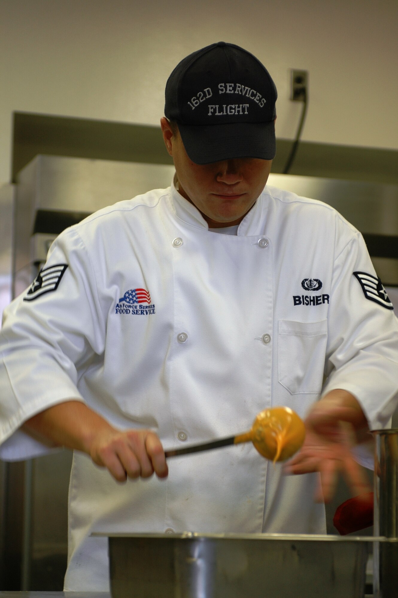 Staff Sgt. Aaron Bisher puts cheese sauce on broccoli. Sergeant Bisher is one of thirty members in food services. (Air National Guard photo by 1st Lt. Dan Dodson)