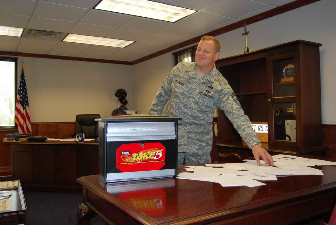Chief Master Sgt. Kenneth Sallinger, 82nd Training Wing Command Chief, selects the "Early Bird" winner of the "Take 5" Balfour Beatty Communities resident satisfaction survey winner Oct. 24. "Early Bird" participants are BBC residents who turned in the survey within the first week. (U.S. Air Force photo/Airman 1st Class Candy Miller)