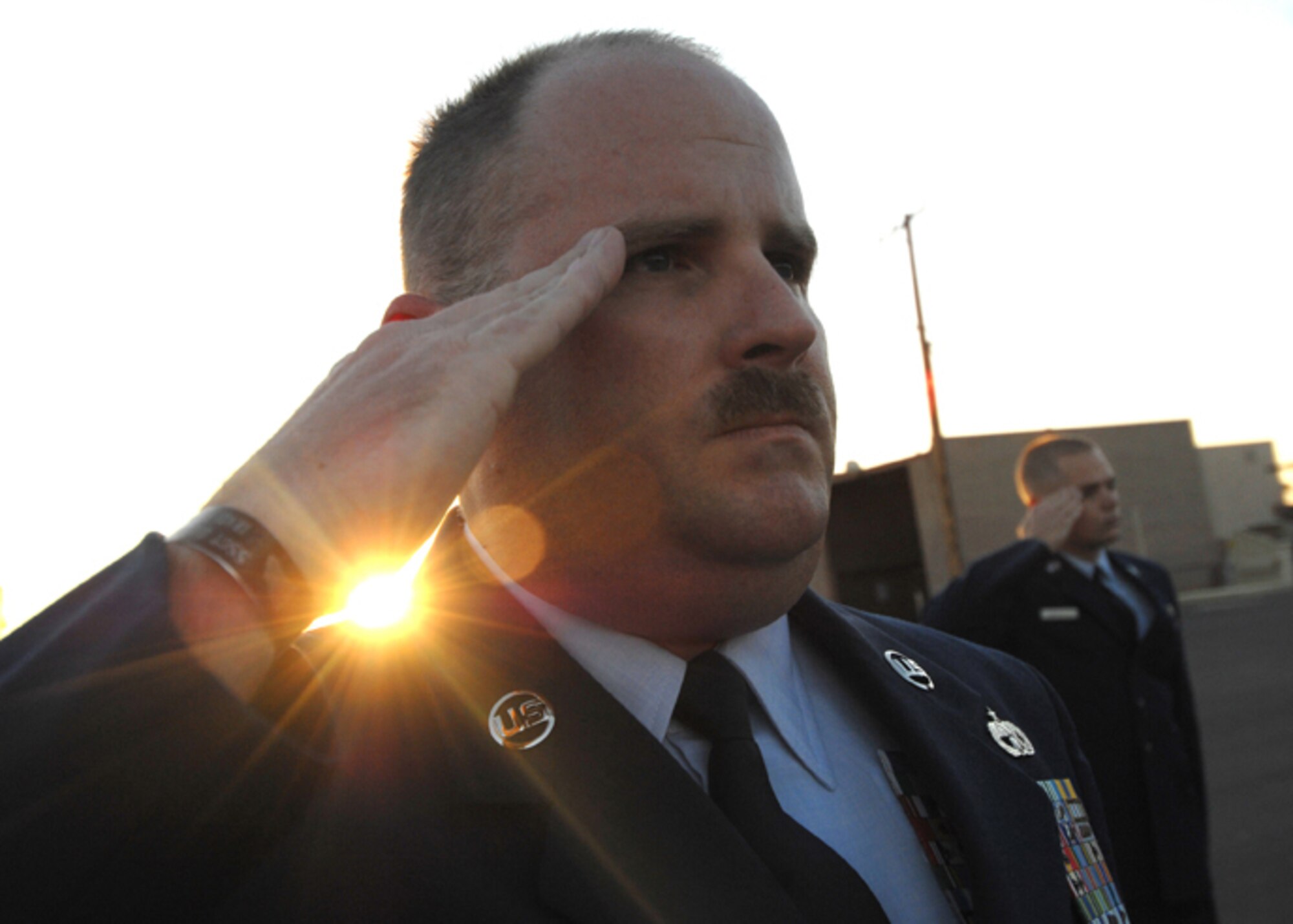 Tech. Sgt. Jerome Baker, 56th Logistics Readiness training NCO, renders a salute as "To The Colors" plays across Luke Air Force Base, AZ.  (U.S. Air Force photo by Tech. Sgt. Jeffrey A. Wolfe)