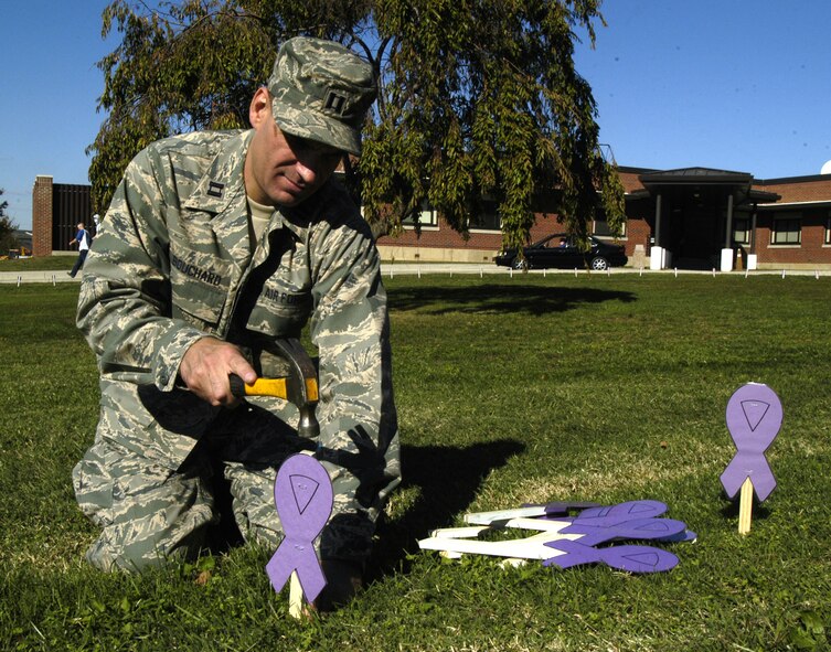 DOVER AIR FORCE BASE, Del. – Capt. Raymond Bouchard, 436th Medical Operations Squadron family advocate officer, sets up purple ribbons outside the horseshoe of the medical treatment facility. The ribbons serve as a reminder for Domestic Violence Awareness month. (U.S. Air Force photo/Airman 1st Class Shen-Chia Chu)                   