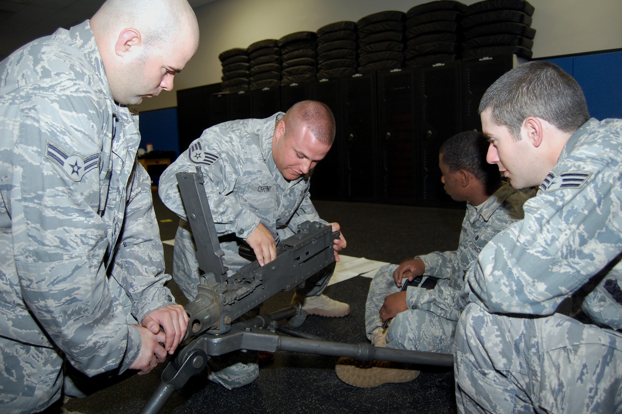 Staff Sgt. Tommy Carpino (center), contingency skills instructor from the 421st Combat Training Squadron, talks to security forces Airmen at the U.S. Air Force Expeditionary Center for training on how to take apart and put back together a .50 caliber machine gun during training in the center on Fort Dix, N.J., Oct. 23, 2008.  The Airmen were training for upcoming deployments to the Southwest Asia deployment theater of operations.  (U.S. Air Force Photo/Tech. Sgt. Scott T. Sturkol)The Airmen were training for upcoming deployments to the Southwest Asia deployment theater of operations.  (U.S. Air Force Photo/Tech. Sgt. Scott T. Sturkol)