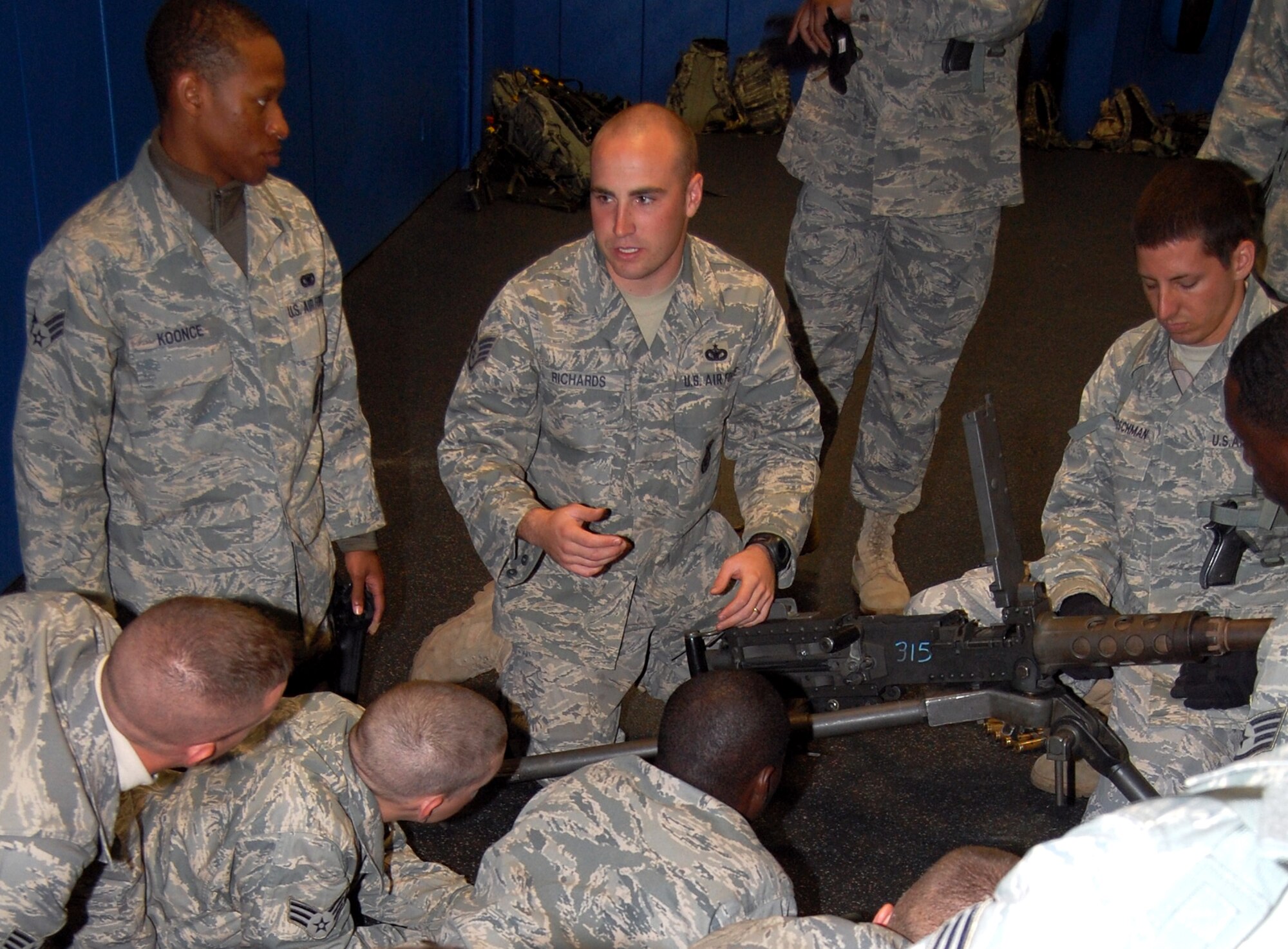 Staff Sgt. Anthony Richards (center), contingency skills instructor from the 421st Combat Training Squadron, talks to security forces Airmen at the U.S. Air Force Expeditionary Center for training on how to take apart and put back together a .50 caliber machine gun during training in the center on Fort Dix, N.J., Oct. 23, 2008.  The Airmen were training for upcoming deployments to the Southwest Asia deployment theater of operations.  (U.S. Air Force Photo/Tech. Sgt. Scott T. Sturkol)