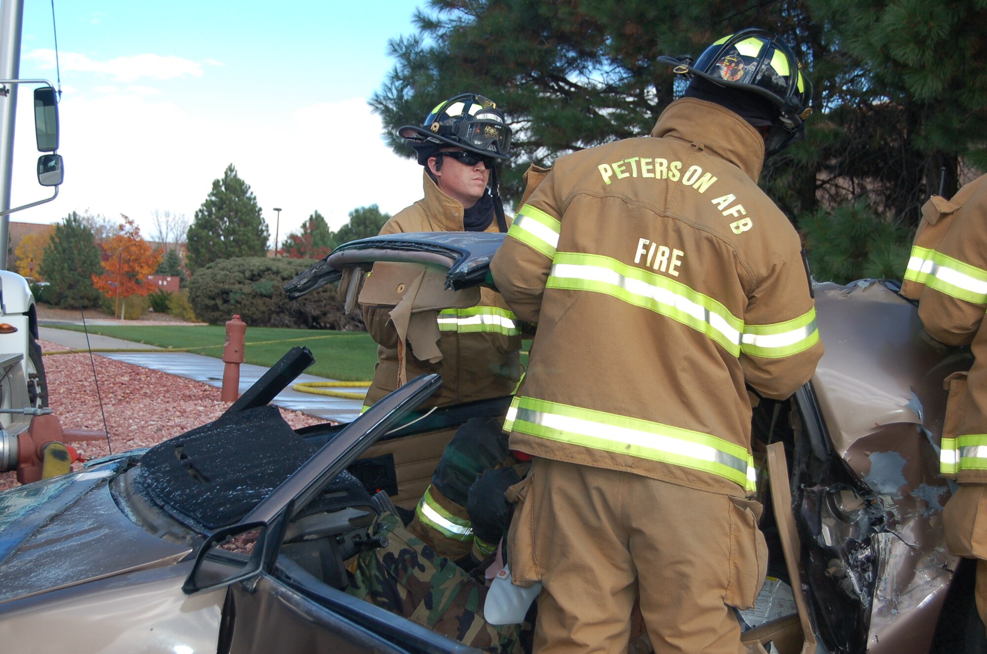 Fire fighters from the Peterson Fire Department rescue a simulated victim from a car crash that caused a mock fuel during the 21st Space Wing’s Condor Crest exercise Oct. 21. (Air Force photo/Corey Dahl) 
