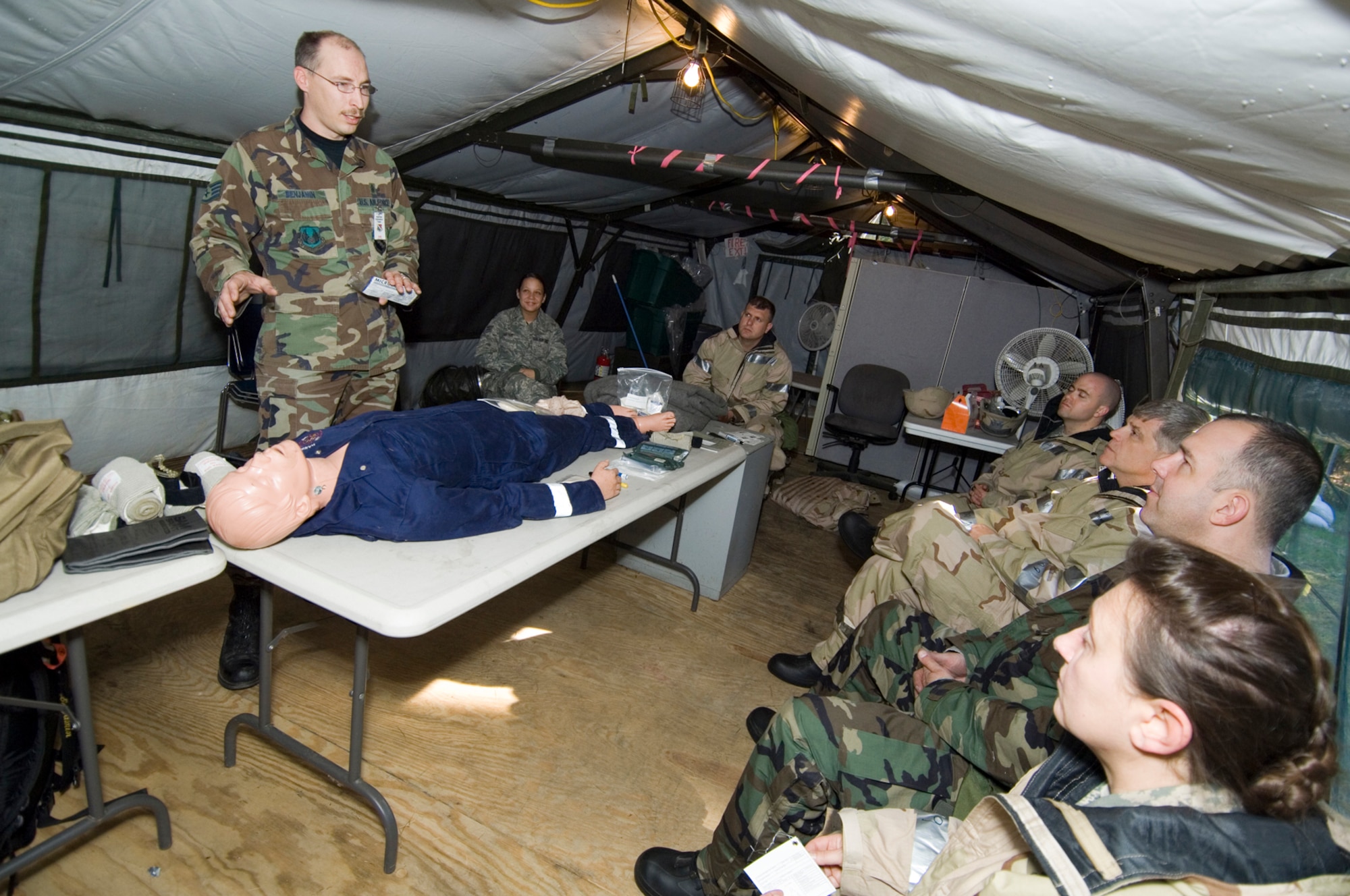 HANSCOM AIR FORCE BASE, Mass. – Staff Sgt. Marcus Benjamin (left), 66th Medical Group, provides life-saving Self Aid and Buddy Care training to Camp Patriot deployers on Oct. 23, during a Base Readiness Exercise to prepare for the Nov. 1-10 Unit Compliance Inspection, Targeted Readiness Inspection. More than 230 Hanscom Airmen participated in readiness training at Camp Patriot focusing on combat skills, AFMAN training, weapons familiarization, CBRNE training and Post Attack Reconnaissance techniques. (U.S. Air Force photo by Rick Berry)