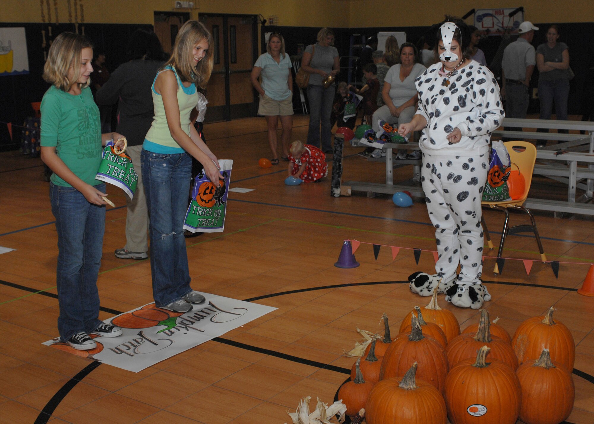 DYESS AIR FORCE BASE, Texas -- Makayla Hendrix and Holly Buff toss rings on pumpkin stems, one of the games at the annual youth center Fall Festival here, Oct. 24. More than 240 Dyess families participated in the event.  (U.S. Air Force photo/Senior Airman Jennifer Romig)
