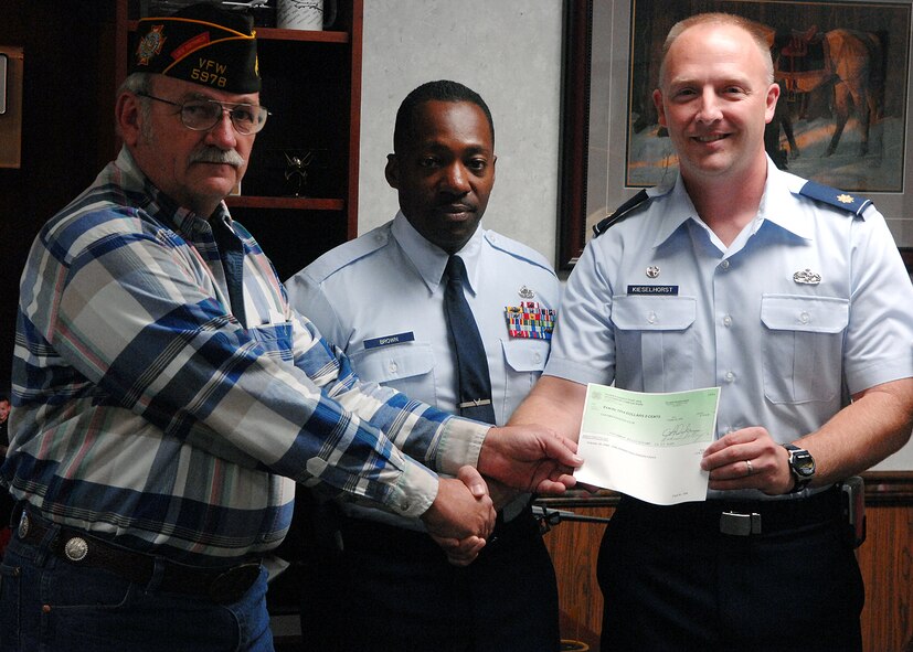 MOODY AIR FORCE BASE, Ga. – Maj. David Kieselhorst, 23rd Equipment Maintenance Squadron commander, and Senior Master Sgt. Gregory Brown, 23rd EMS first sergeant, receive a check Oct. 21 here from Klim Nessmith, Senior Vice Commander of the Veterans Foreign Wars Post 5978. The VFW adopts squadrons from every service to provide support for service members. (U.S. Air Force photo by Airman Joshua Green) 
