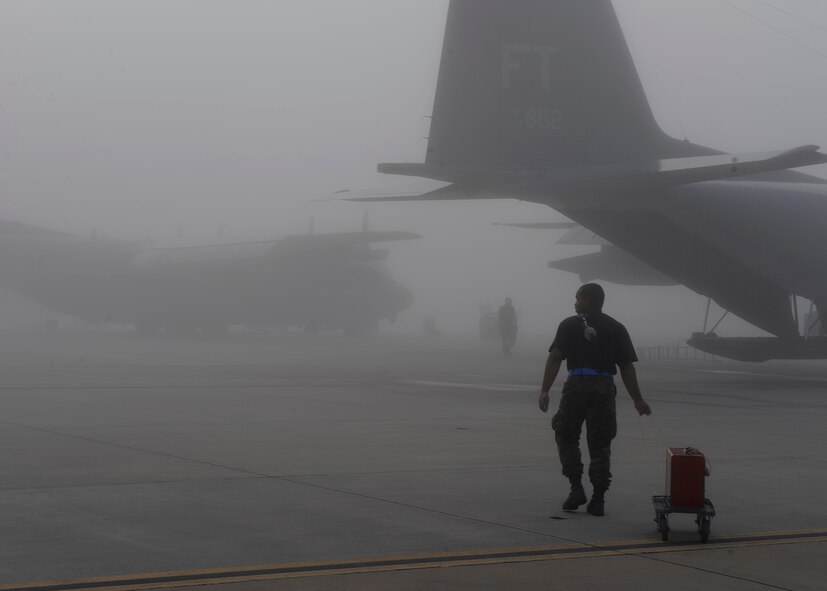 MOODY AIR FORCE BASE, Ga. – An Airmen from the 723rd Aircraft Maintenance Squadron carries tools out to a HC-130P Hercules Oct. 16 here. Thick fog doesn’t stop maintainers from performing their regular scheduled duties. (U.S. Air Force photo by Senior Airman Brittany Barker)

