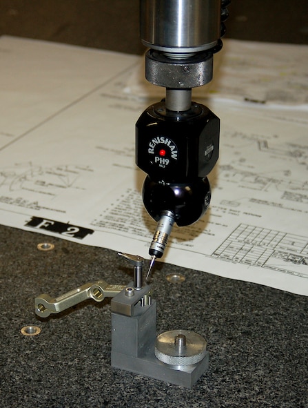 Critical features of a finished T-38 aileron lever are checked for accuracy on a Coordinate Measuring Machine. (U.S. Air Force photo by Bill Orndorff)