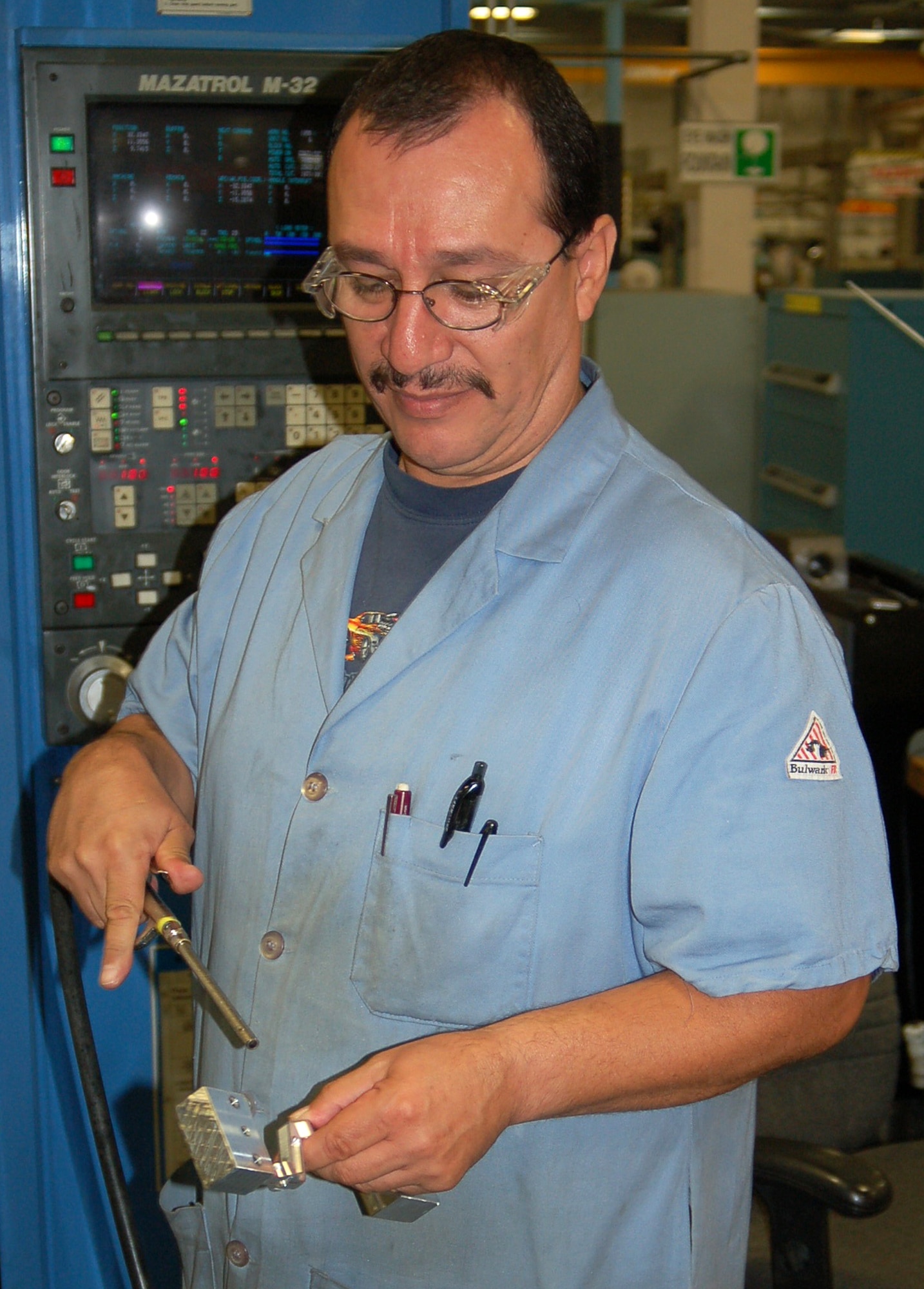 Louis Macias, 530th Commodities Maintenance Squadron machinist, air blasts a newly manufactured T-38 aileron lever to remove excess coolant following the third machine operation. (U.S. Air Force photo by Bill Orndorff)