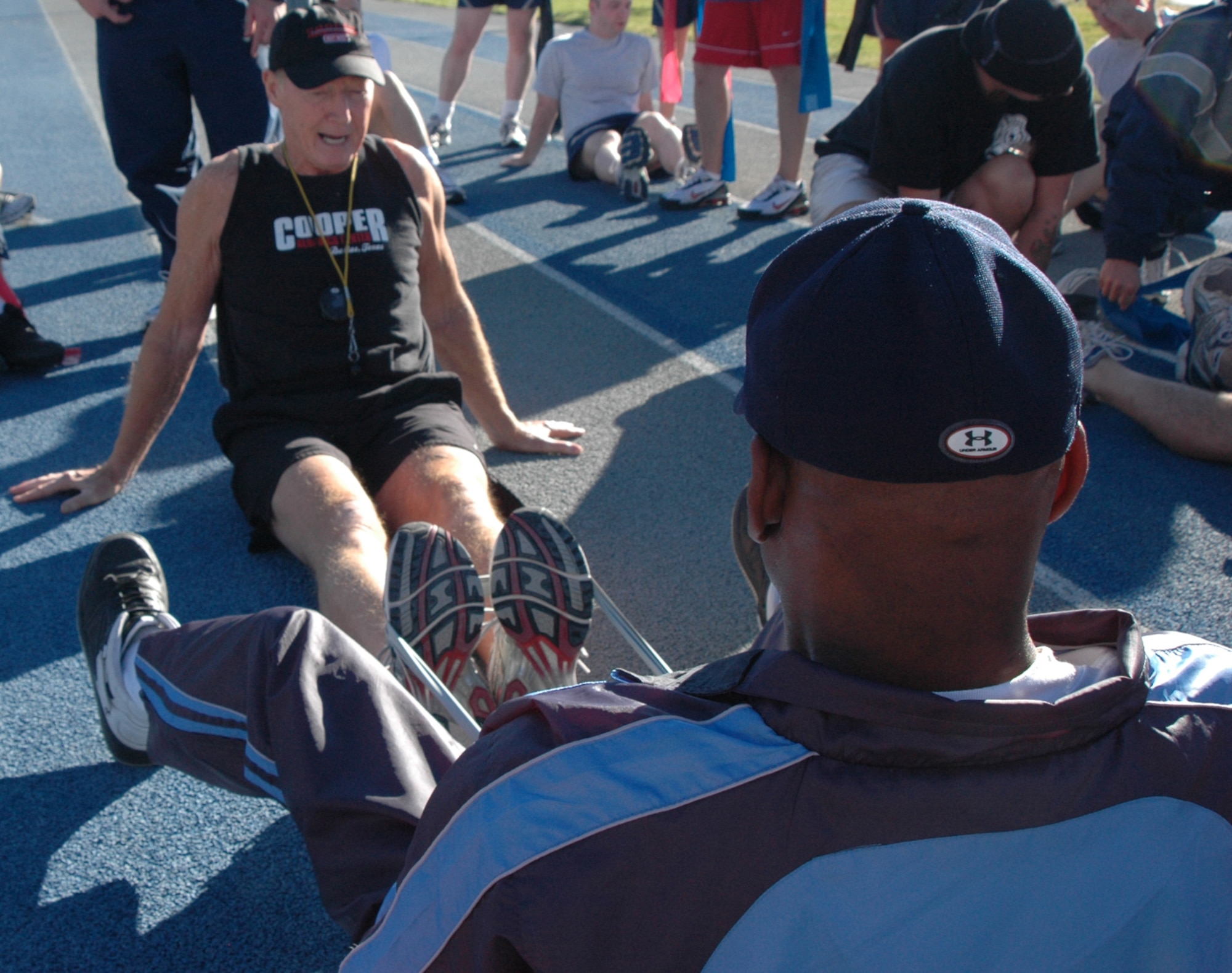 Roger Reynolds, director of contact relations at the Cooper institute, performs strenghthening exercises using a band with a student Oct. 24.