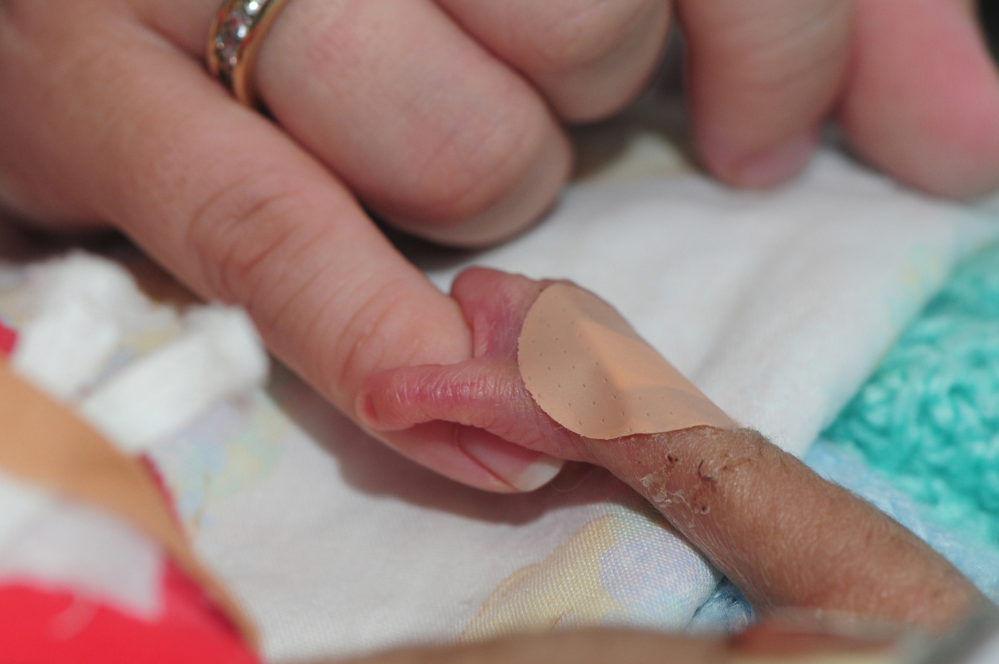 Eric LeVon Frazier II grips his mom's little finger as she puts her hand in his incubator to touch him. Eric and his twin sister, Alexis, were born prematurely at just 23 weeks and 3 days. Between them they weighed barely more than a regular-sized bag of sugar. Dad, Tech. Sgt. Barry Frazier, 100th Air Refueling Wing Legal Office, and mom Mandy, say they have been given outstanding support from the doctors and nurses at the Norfolk and Norwich University Hospital, where the twins were born Sept. 6. (U.S. Air Force photo by Karen Abeyasekere)