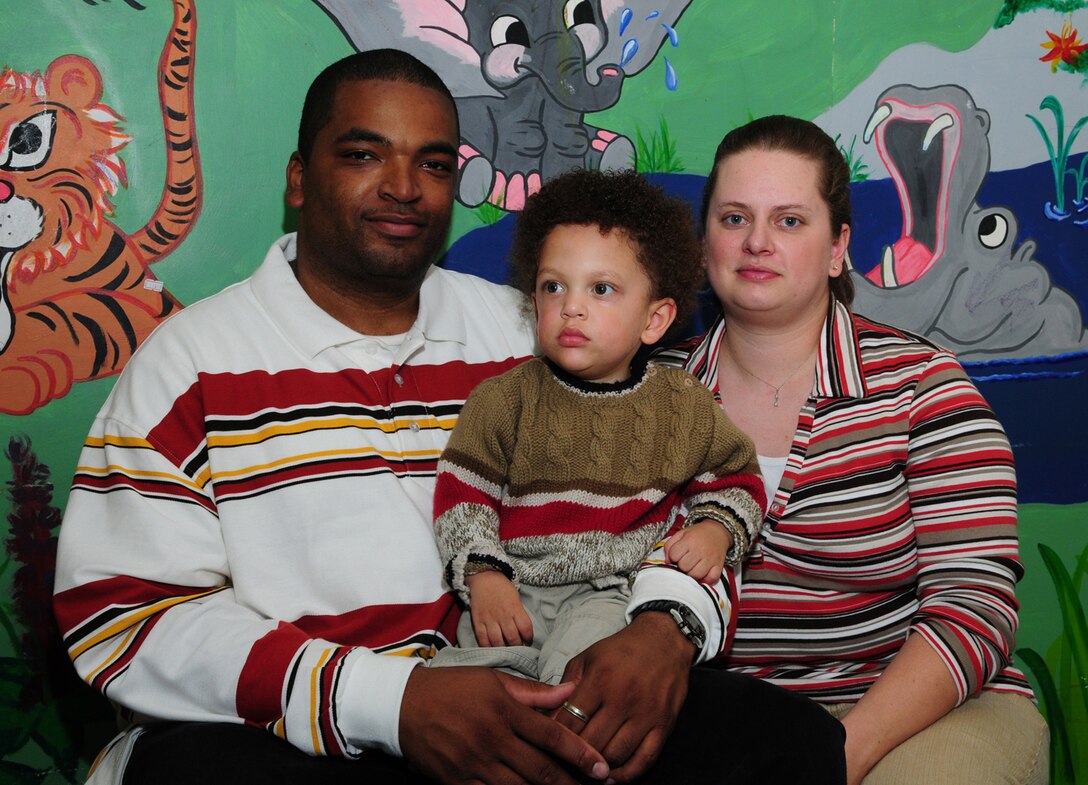 Tech. Sgt. Barry Frazier, 100th Air Refueling Wing Legal Office, his son, Barry Frazier III, and wife Mandy, wait in the children's play room at the Norfolk and Norwich University Hospital. The couple's twin babies, Eric and Alexis, were born Sept. 6 -- at just 23 weeks and three days gestation period. Eric weighed just 1 pound, 5 ounces, and Alexis weighed 1 pound, 3 ounces. Their older brother Barry, pictured here, was also born prematurely at just 26 weeks. He reached his second birthday Oct. 15. (U.S. Air Force photo by Karen Abeyasekere)
