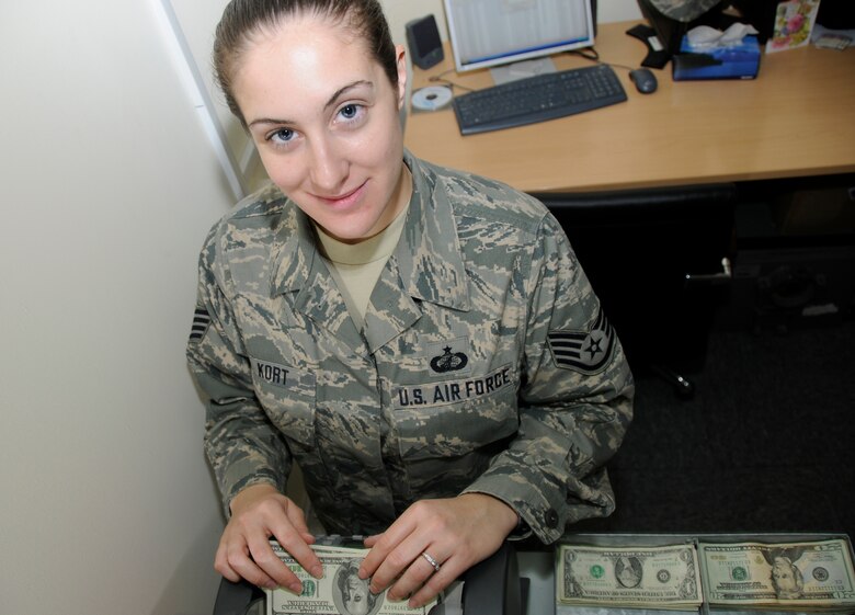 SOUTHWEST ASIA -- Staff Sgt. Shanon Kort from the 380th Air Expeditionary Wing finance office counts cash on a money counter here. The money counter is used to accurately count large stacks of money in a timely manner. Sergeant Kort works in the finance office which is in charge of all monetary transactions used to continue the global war on terrorism. Sergeant Kortis an Air National guardsman deployed from the 105th Airlift Wing, Newburgh N.Y. Her hometown is Mahopac, N.Y. (U.S. Air Force photo/Tech. Sgt. Christopher A. Campbell)(released)