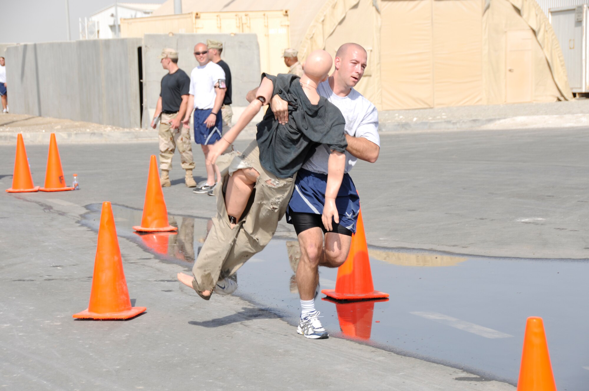 SOUTHWEST ASIA -- Capt. Jason Seelhorst from the 380th Air Expeditionary Wing runs with a victim through an obstacle course during a fire muster here. The event had each member run with a victim solo, followed by a team litter obstacle course. The Expeditionary fire department held a fire muster for morale and team building. Captain Seelhorst is deployed from the 5th Bomb Wing, Minot Air Force Base N.D. His hometown is Aberdeen, S.D.(U.S. Air Force photo/Tech. Sgt. Christopher A. Campbell)(released)