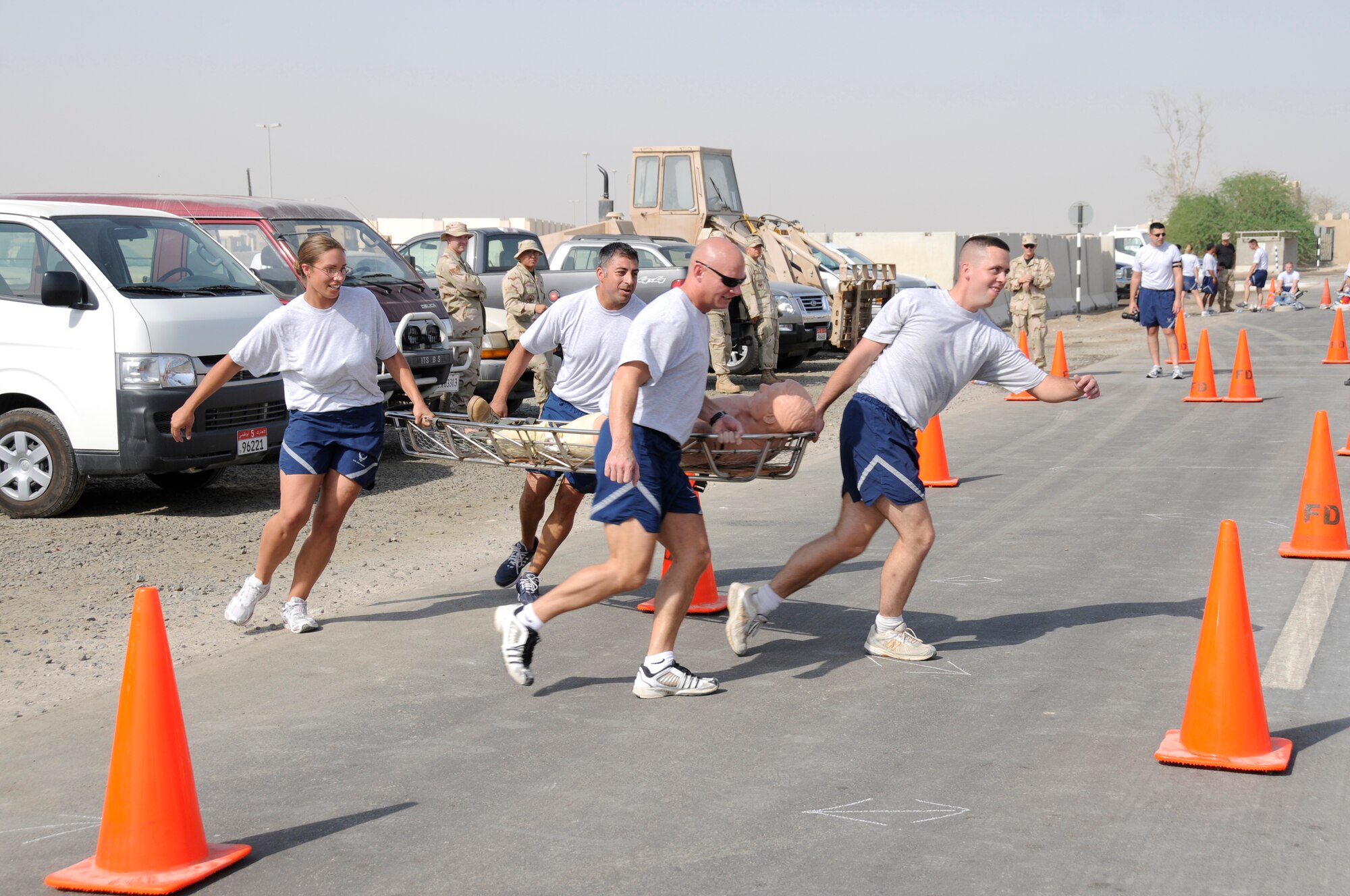 SOUTHWEST ASIA -- Members of 380th Expeditionary Civil Engineer Squadron team three run through a litter obstacle course during a fire muster here Oct. 9. The Expeditionary fire department held a fire muster for morale and team building.  (U.S. Air Force photo/Tech. Sgt. Christopher A. Campbell)(released)