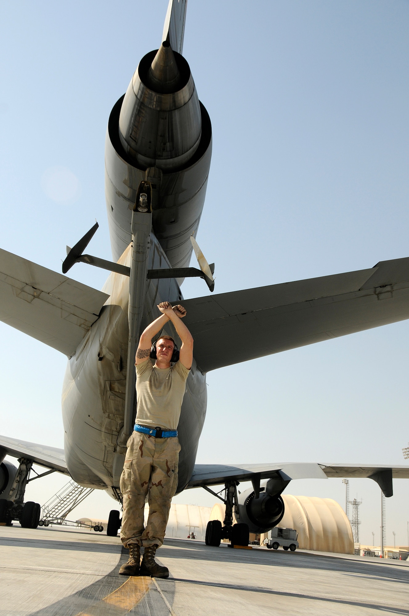 SOUTHWEST ASIA -- Senior Airman William Brigham from the 380th Expeditionary Aircraft Maintenance Squadron directs a KC-10 prior to take-off here to ensure the safety of the crew, personnel on the flight line and other aircraft in the area. The KC-10s, out of the 380th, provide gas to all aircraft flying in the Area of Responsibility in support of the war on terrorism. The KC-10s from the 380th Air Expeditionary Wing provide gas to all aircraft flying in the Area of Responsibility in support of the war on terrorism. Airman Brigham is deployed from the 660th AMXS, Travis Air Force Base, Calif., his hometown is Eatonville, Wash. (U.S. Air Force photo/Tech. Sgt. Christopher A. Campbell)(released)