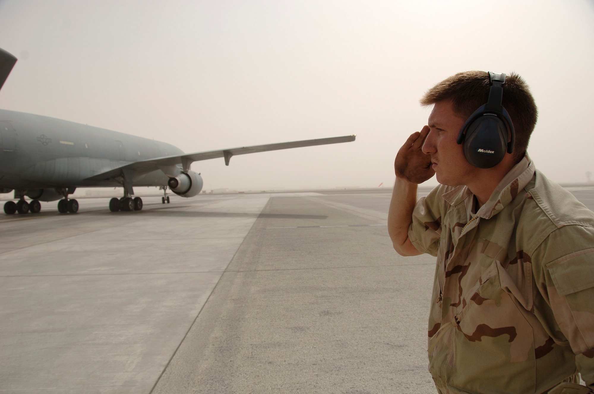 Senior Airman William Brigham from the 380th Expeditionary Aircraft Maintenance Squadron renders a salute to a KC-10 here. This is one of the procedures for the maintenance personnel to perform during the takeoff of an aircraft.  The KC-10's, out of the 380th, provide gas to all aircraft flying in the Area of Responsibility in support of the war on terrorism. Airman Brigham is deployed from the 660th AMXS Travis Air Force Base, Calif., his hometown is Eatonville, Wash. (U.S. Air Force photo/Tech. Sgt. Christopher A. Campbell)(released)