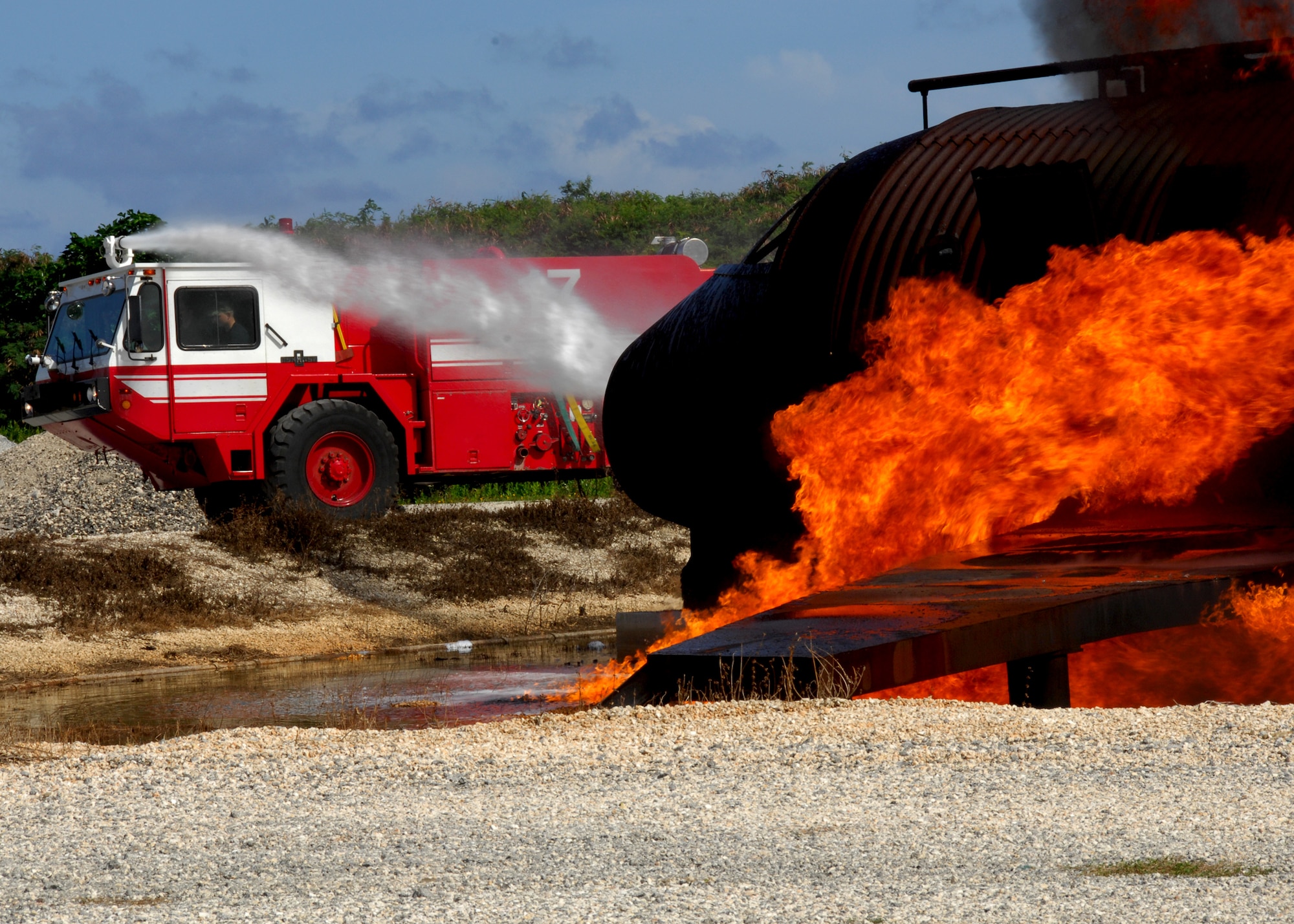 ANDERSEN AIR FORCE BASE, Guam -Andersen Fire and Emergency Service firefighters use Fire Engine 17 to extinguish the simulated aircraft fire here Oct. 24. The aircraft live-fire trainer and the structural trainer are used quarterly to conduct live-fire quarterly. (U.S. Air Force photo by Airman 1st Class Nichelle Griffiths)