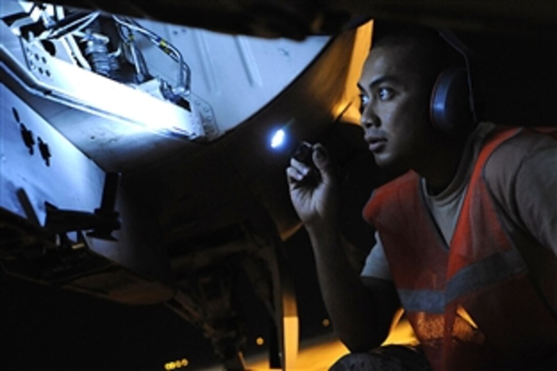 U.S. Air Force Airman 1st Class Holy Douangmala prepares to install munition safety pins on an F-16 Fighting Falcon aircraft on a hot cargo pad on Joint Base Balad, Iraq, Oct. 21, 2008. Douangmala is a weapons load crew member is assigned to the 332nd Expeditionary Aircraft Maintenance Squadron. The safety pins prevent unintentional deployment of munitions once the aircraft has landed.