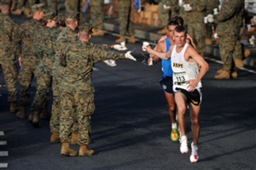 U.S. Army 2nd Lt. Kenneth Foster and Jose Miranda of Mexico receive water support from Marines during the 33rd running of the Marine Corps Marathon on Oct. 26, 2008. Foster set the pace for a lead pack of five runners through 11 miles before fading to a 10th-place finish with a time of 2 hours, 59 minutes, 29 seconds. Miranda finished sixth in 2:26:48. Andrew Dumm, 23, of Washington, won the 26.2-mile race with a time of 2:22:42 in his first marathon.
