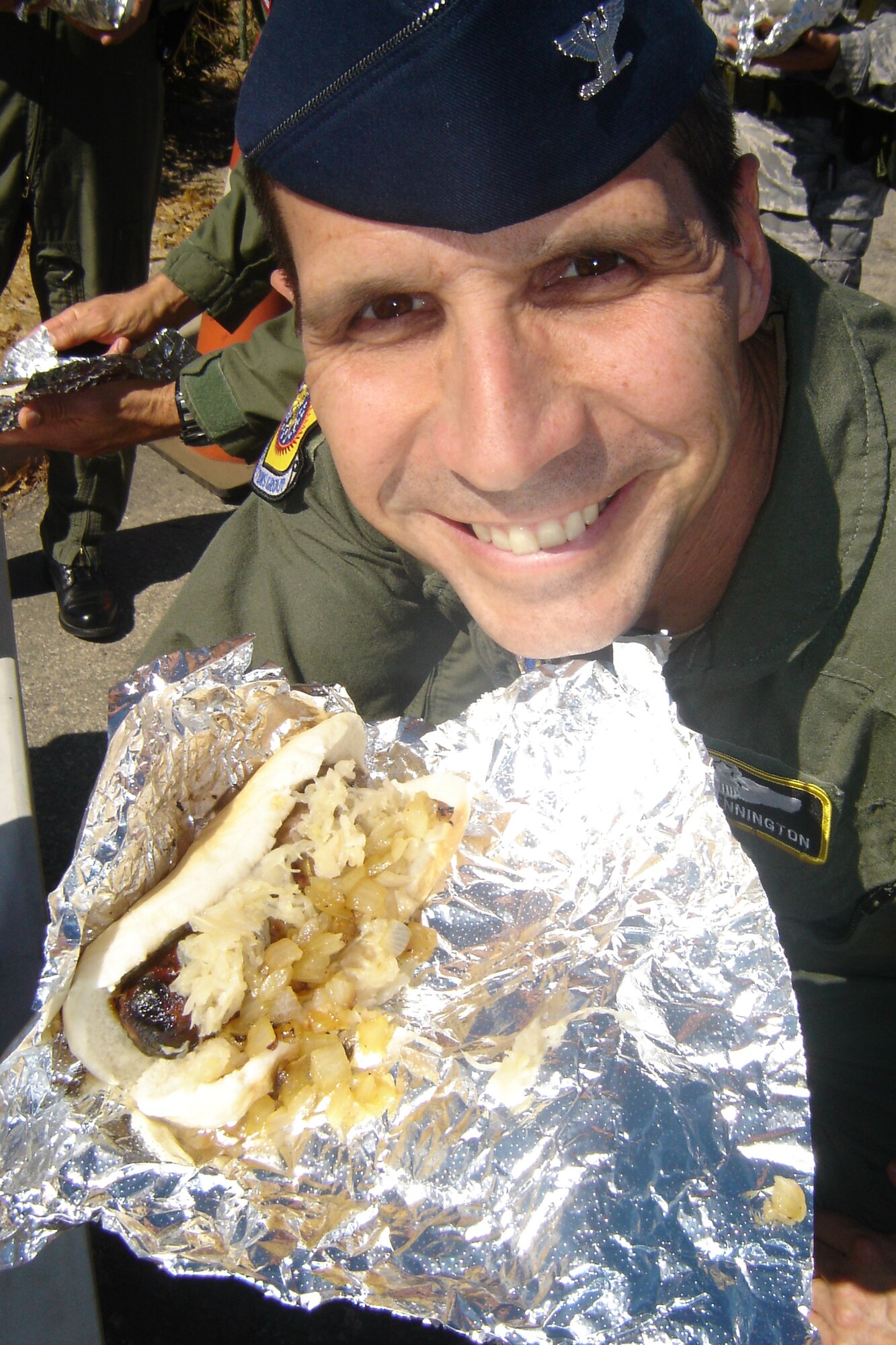 Col. Jeffrey T. Pennington, 452 OG commander, shows off his lunch during a Brat Burn Friday sponsored by the March Company Grade Officers Council. (U.S. Air Force photo by Will Alexander)