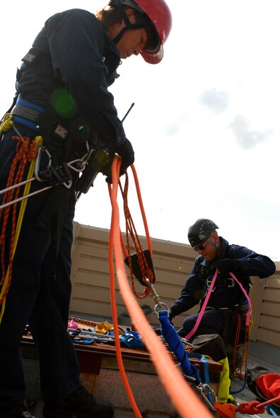 KUNSAN AIR BASE, Republic of Korea -- A Kunsan national fire fighter and a 8th Civil Engineer Squadron fire fighter work together during the ascending and descending rope rescue Technical One Training here, Oct 28. Air Force fire fighters and Korean national fire fighters train together on a regular bases on ascending and descending rope rescue training.(U.S. Air Force photo/Senior Airman Gustavo Gonzalez)