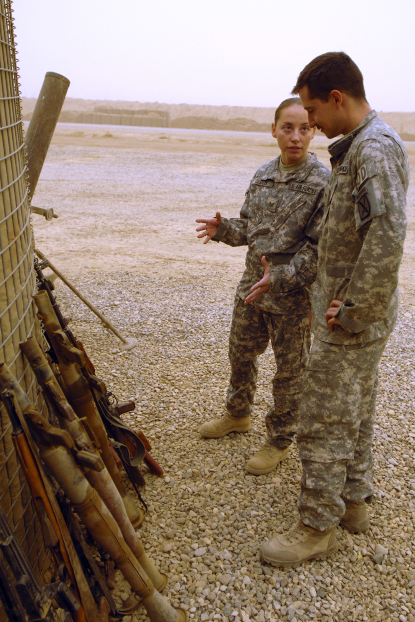 Staff Sergeant Angela “O” Olguin and Senior Airman Joshua Brum, 506th Air Expeditionary Group Explosive Ordnance Disposal flight technicians, discuss the disposal of insurgent weapons and ordnance Sept. 15. Both Airmen are forward deployed to FOB McHenry where they are embedded with soldiers of the Army’s 10th Mountain Division. Both Airmen are also deployed from Nellis Air Force Base, Nev. (U.S. Air Force photo/Tech. Sgt. Jeff Walston)