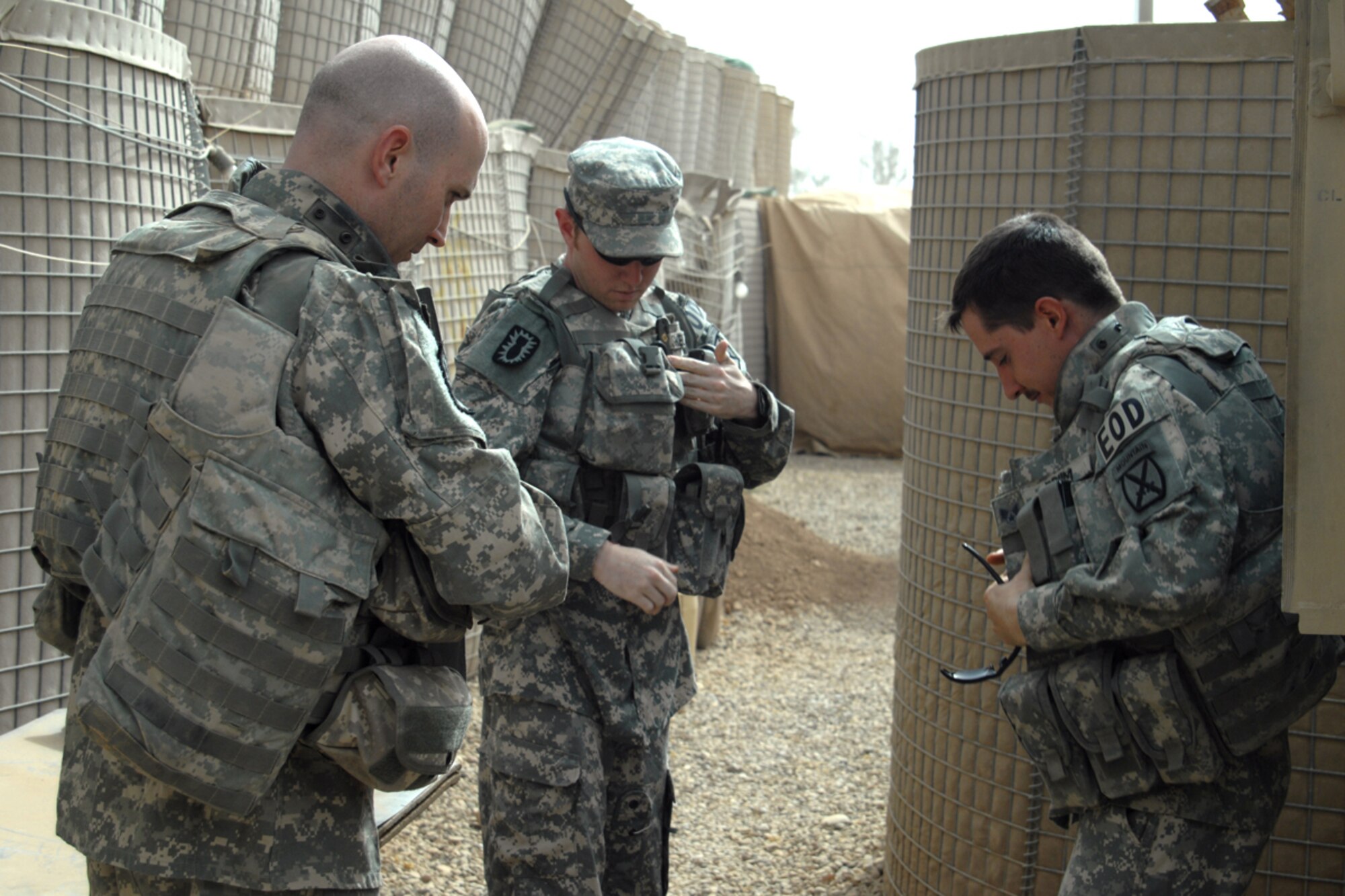 506th Air Expeditionary Group Explosive Ordnance Disposal flight members Tech. Sgt. Stephen Ray Hunter Jr., Senior Airman Aaron Skelton and Senior Airman Joshua Brum, gear up as they practice getting their equipment ready to roll out Sept. 14. The Airmen are forward deployed to FOB McHenry where they are embedded with soldiers of the Army’s 10th Mountain Division for route clearing duties. (U.S. Air Force photo/Tech. Sgt. Jeff Walston)