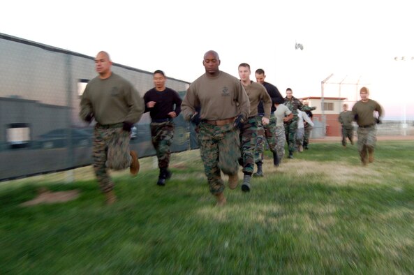 Edwards Airmen and Marines run together as part of a warm up exercise for the Marine Corps Martial Arts Program introduction to the 95th Medical Group facility security team's annual readiness training. The martial arts program is a variation of different martial arts including karate, judo, aikido and Greco-Roman wrestling. (Air Force photo by Senior Airman Julius Delos Reyes)