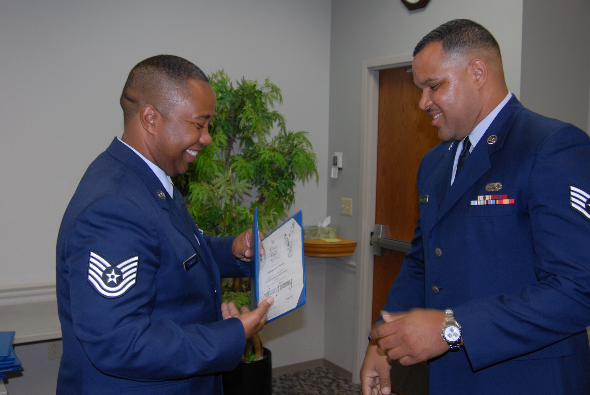 A hard earned education certificate goes to Staff Sgt. Eric Nicholson. Tech. Sgt. Marlon Crawford (left), from the 932nd Airlift Wing's education office, congratulates the new NCO Leadership Develop course graduate recently.. (U.S. Air Force photo/Maj. Stan Paregien) 